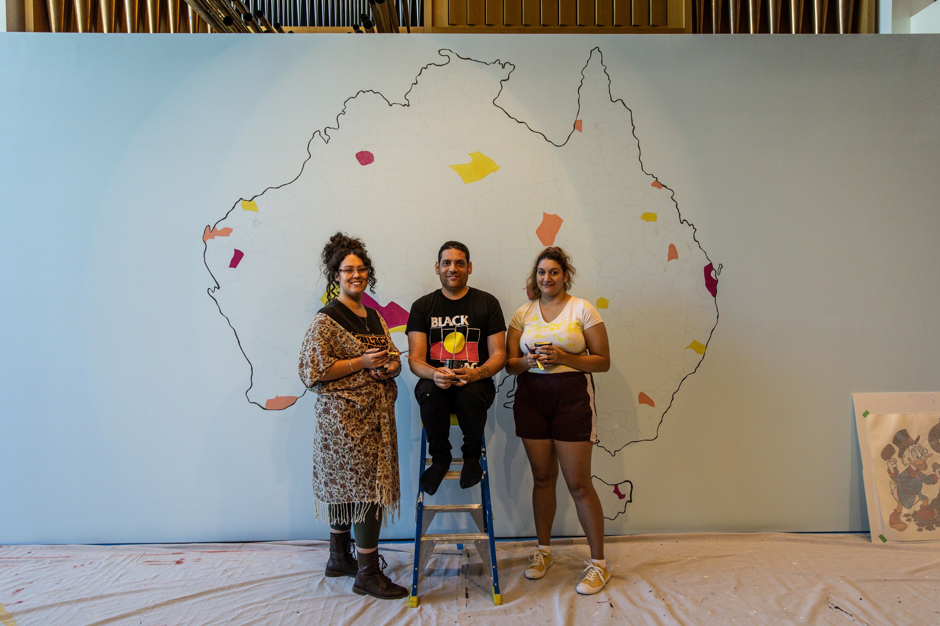 Artist Tony Albert with two students