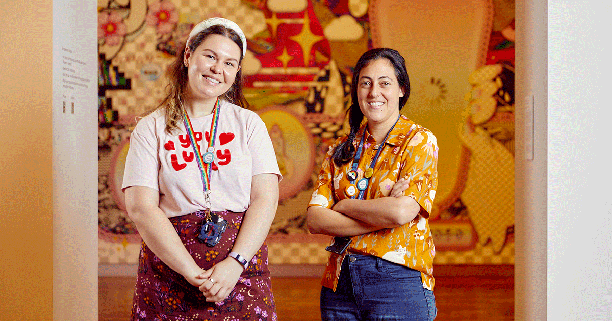 Two mediators smiling at the camera, they wear lanyards with badges on them