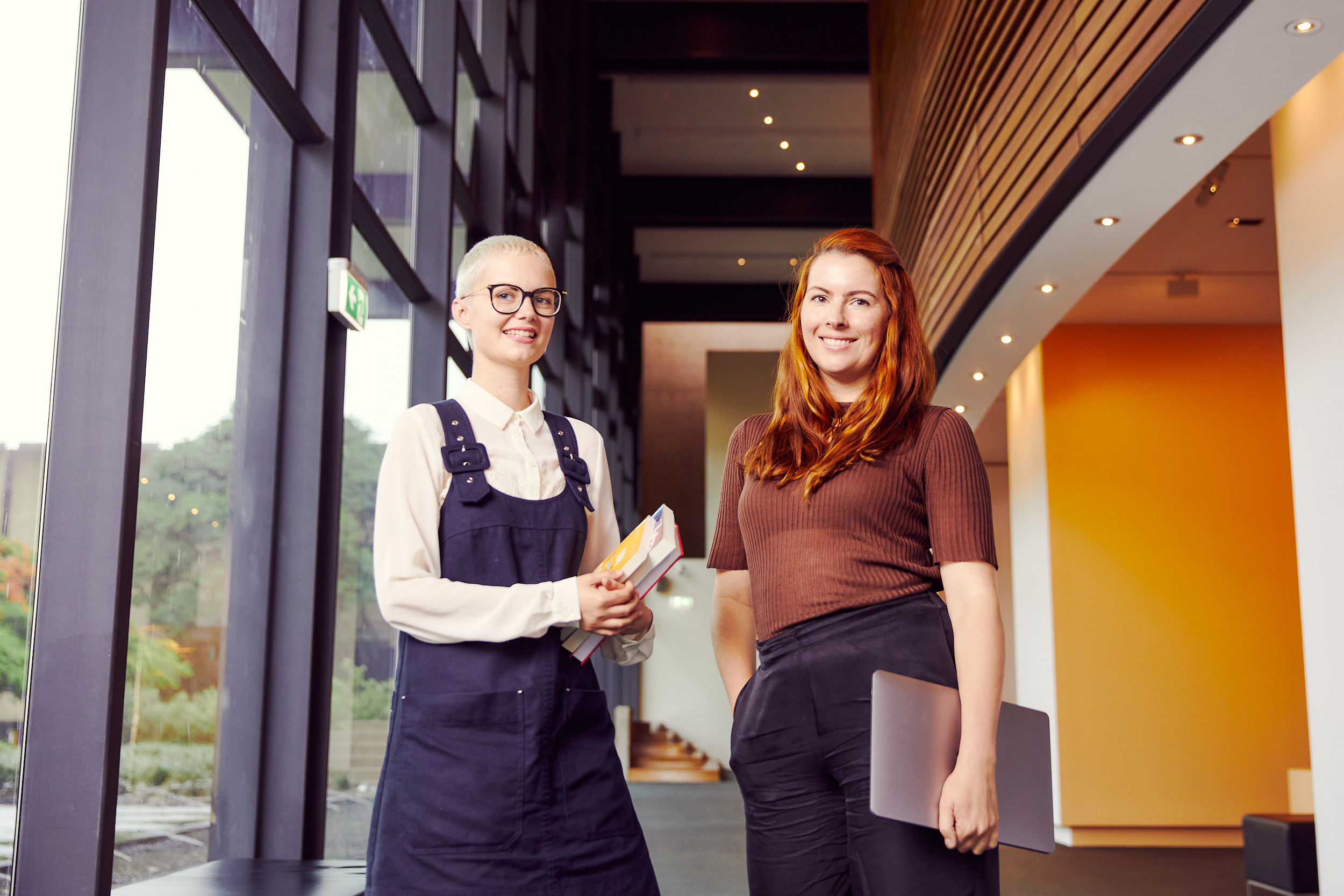 An intern and her supervisor standing in the art museum foyer