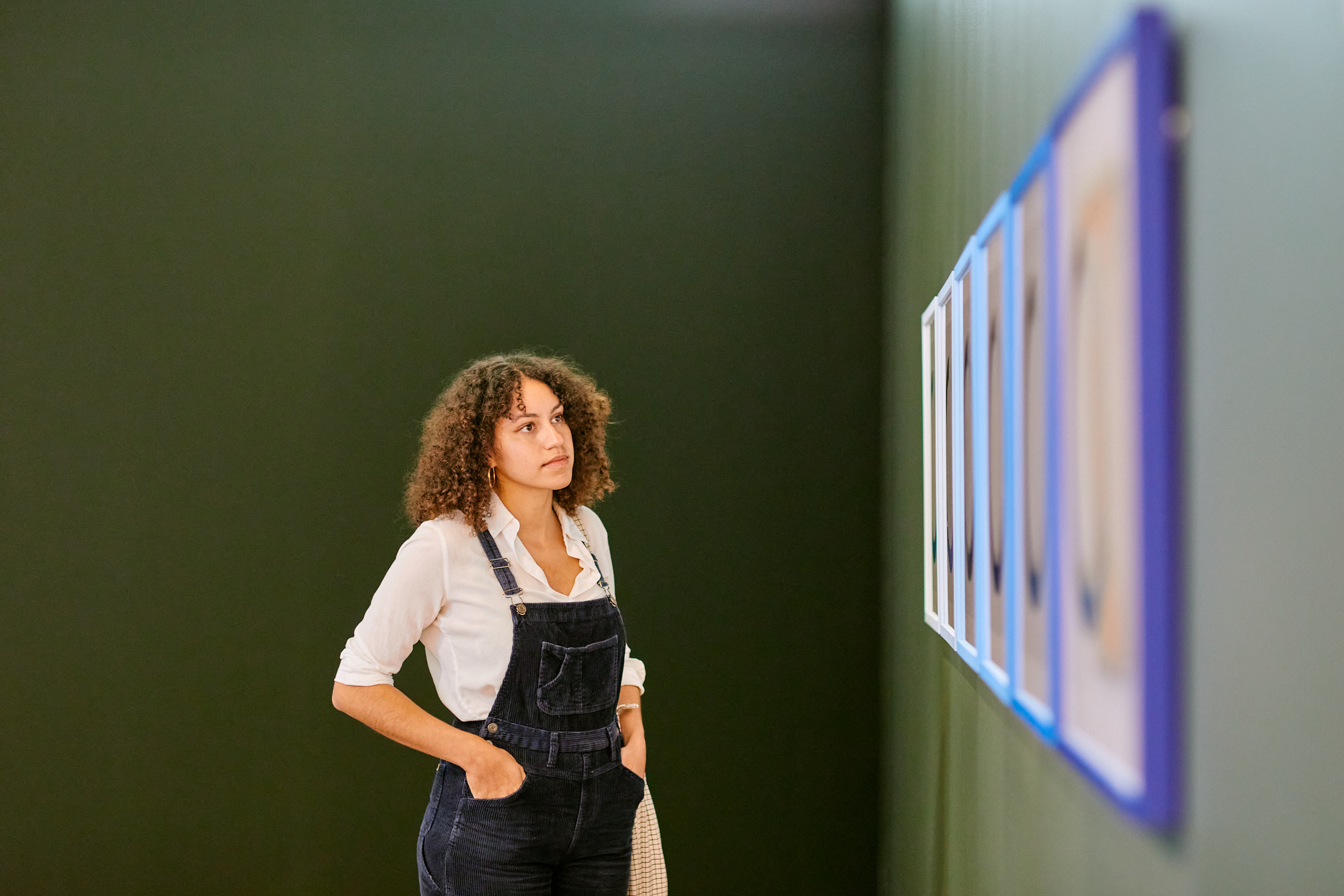 Student looking at paintings on a wall