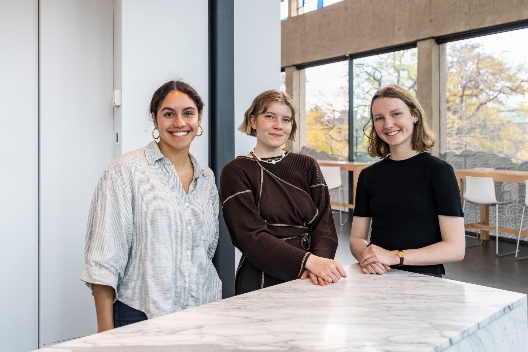 Three students smiling at the camera