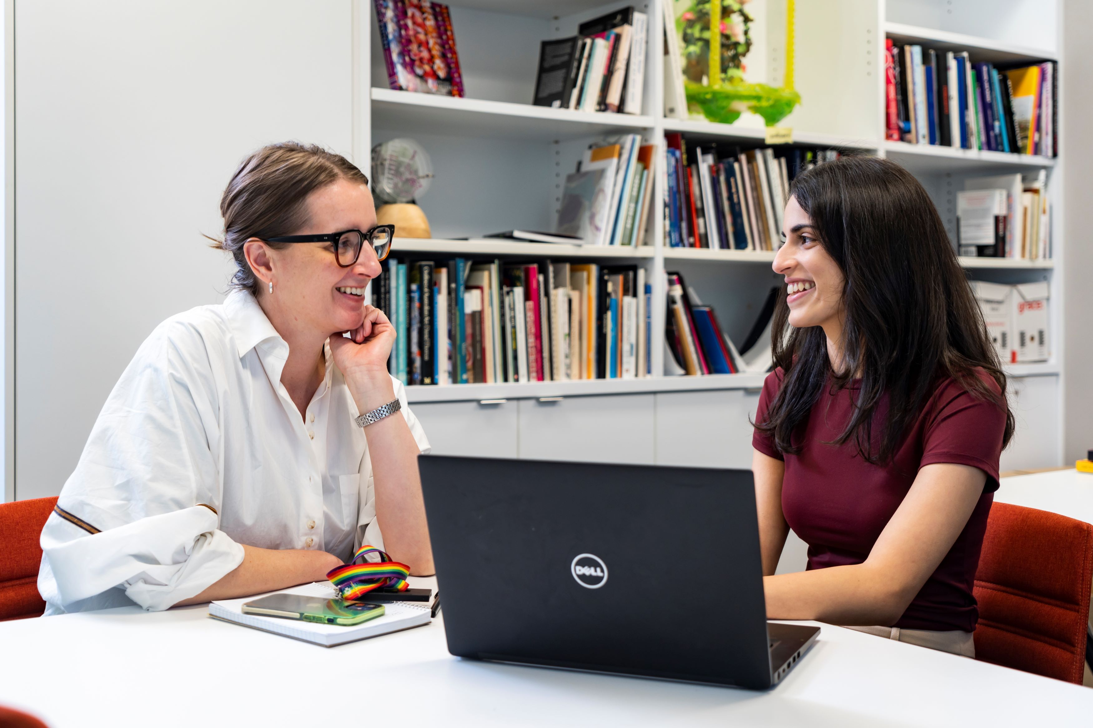 An intern and staff member sitting in an office smiling and talking