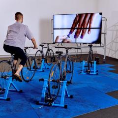 Person cycling in front of a screen