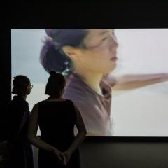 Two people looking at a video artwork