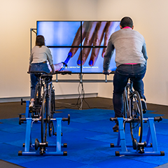Two people riding bicycles as part of Eugenia Lim's artwork "On Demand"