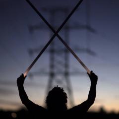 Still from an artwork showing a person holding fluoroescent light tubes