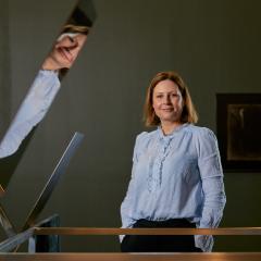 Holly standing next to an artwork and smiling at the camera