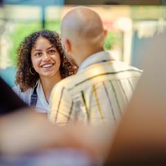 A staff member smiles as they listen to someone speaking