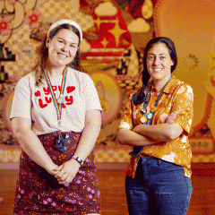 Two staff members wearing ally and pronoun badges