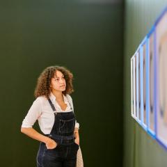 A person looking at artworks in a gallery space